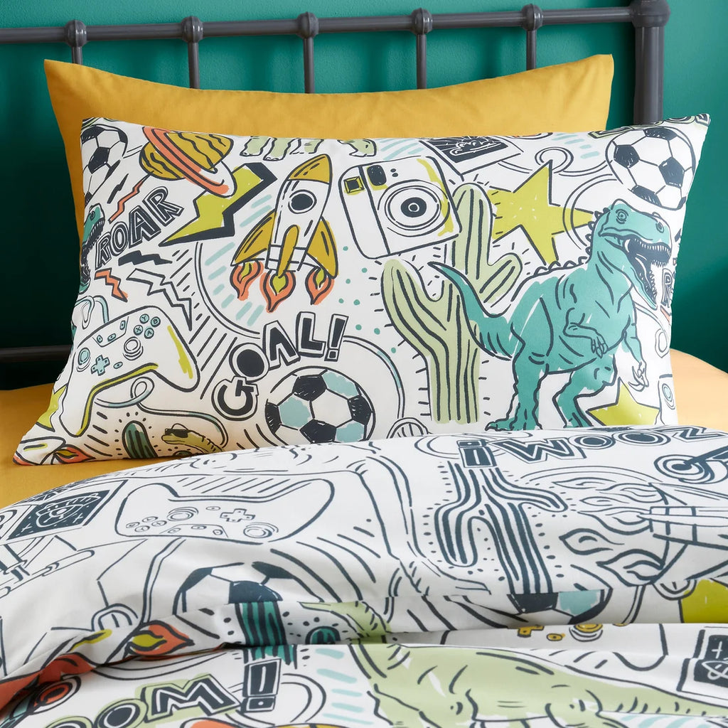 Children's bedding set with dinosaur and sports theme on a bed with yellow pillow.