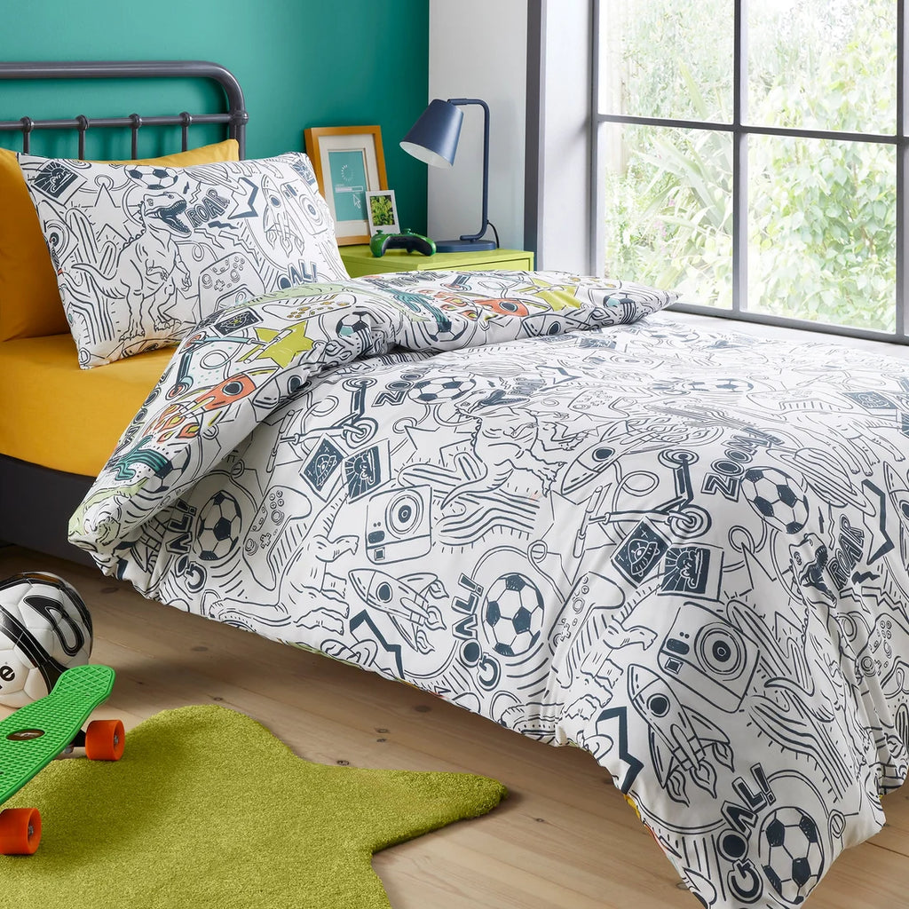 Children's bedroom with a bed featuring a sports-themed bedding set, skateboards on the floor, and a window with greenery outside.