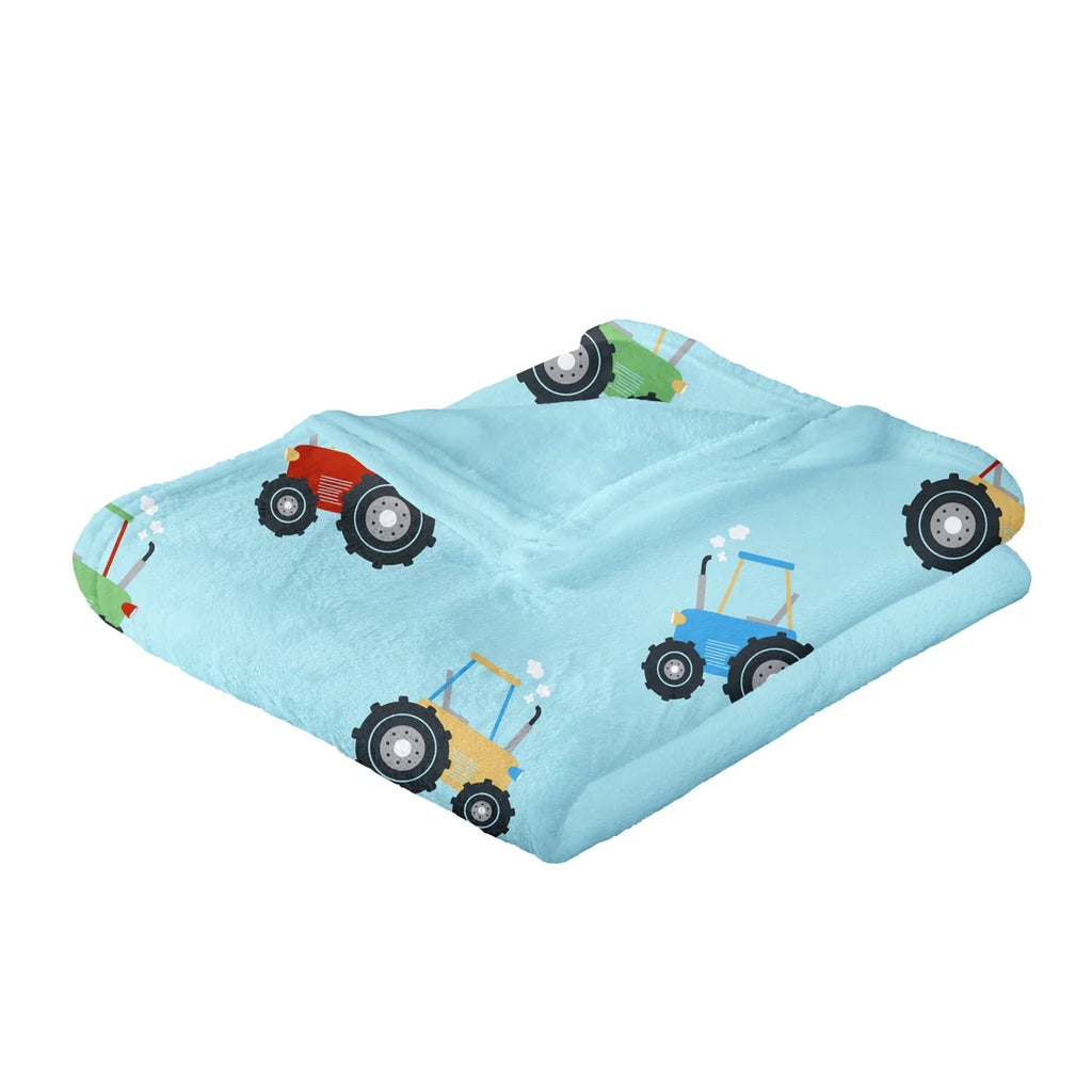 Close-up of the colourful tractor print on the Bedlam Farmyard Friends throw.