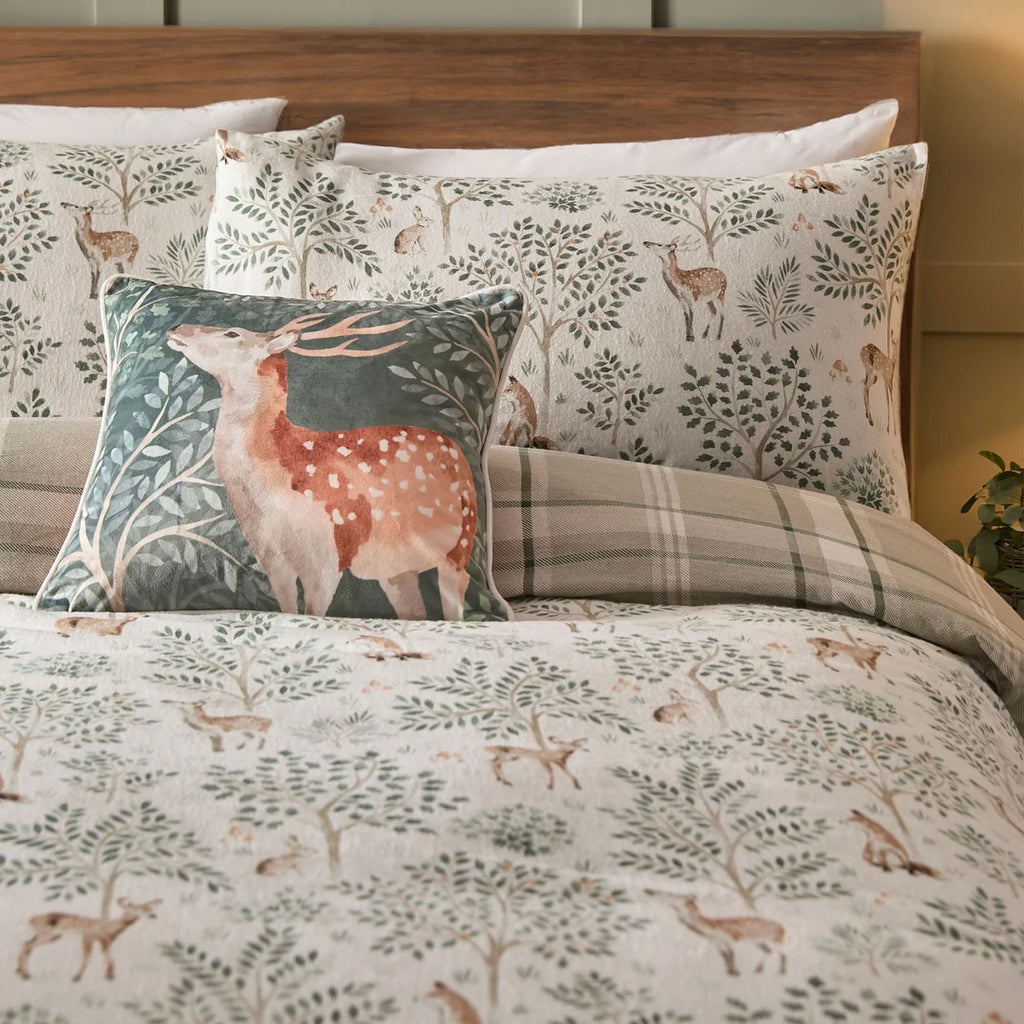 Close-up of the hand-painted woodland animals and evergreen tree design on the Dreams & Drapes Forest Animals duvet cover set.