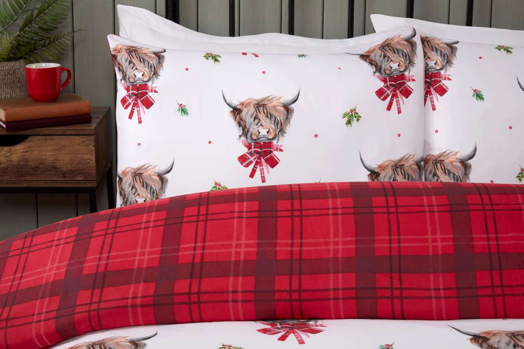 Close-up of the Highland cow print with festive red bow details on the Fergus duvet cover set.