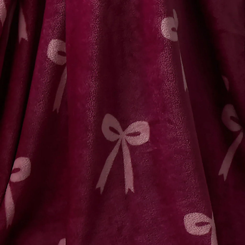 Close-up of the soft fleece fabric on the Fusion Bows berry throw.
