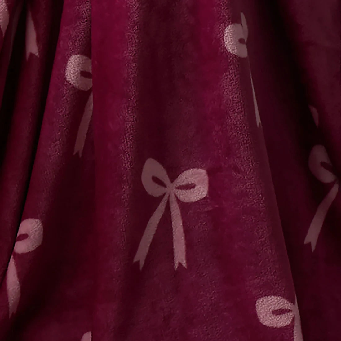 Close-up of the soft fleece fabric on the Fusion Bows berry throw.