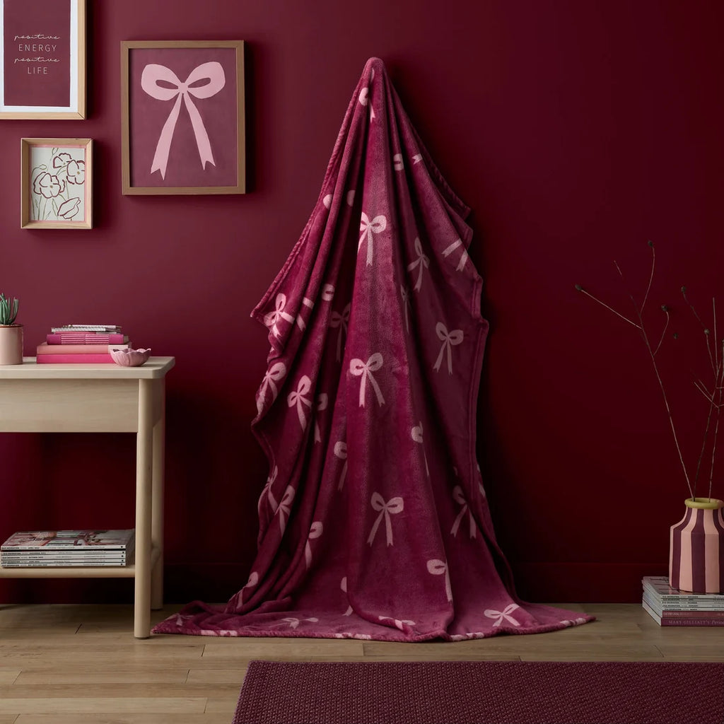 Fusion Bows fleece throw in berry with a stylish ribbon bow design.