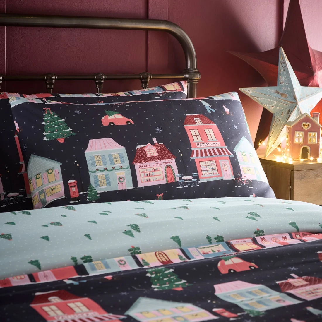 Close-up of the colourful houses and winter scenes on the Fusion Christmas Houses Navy bedding.