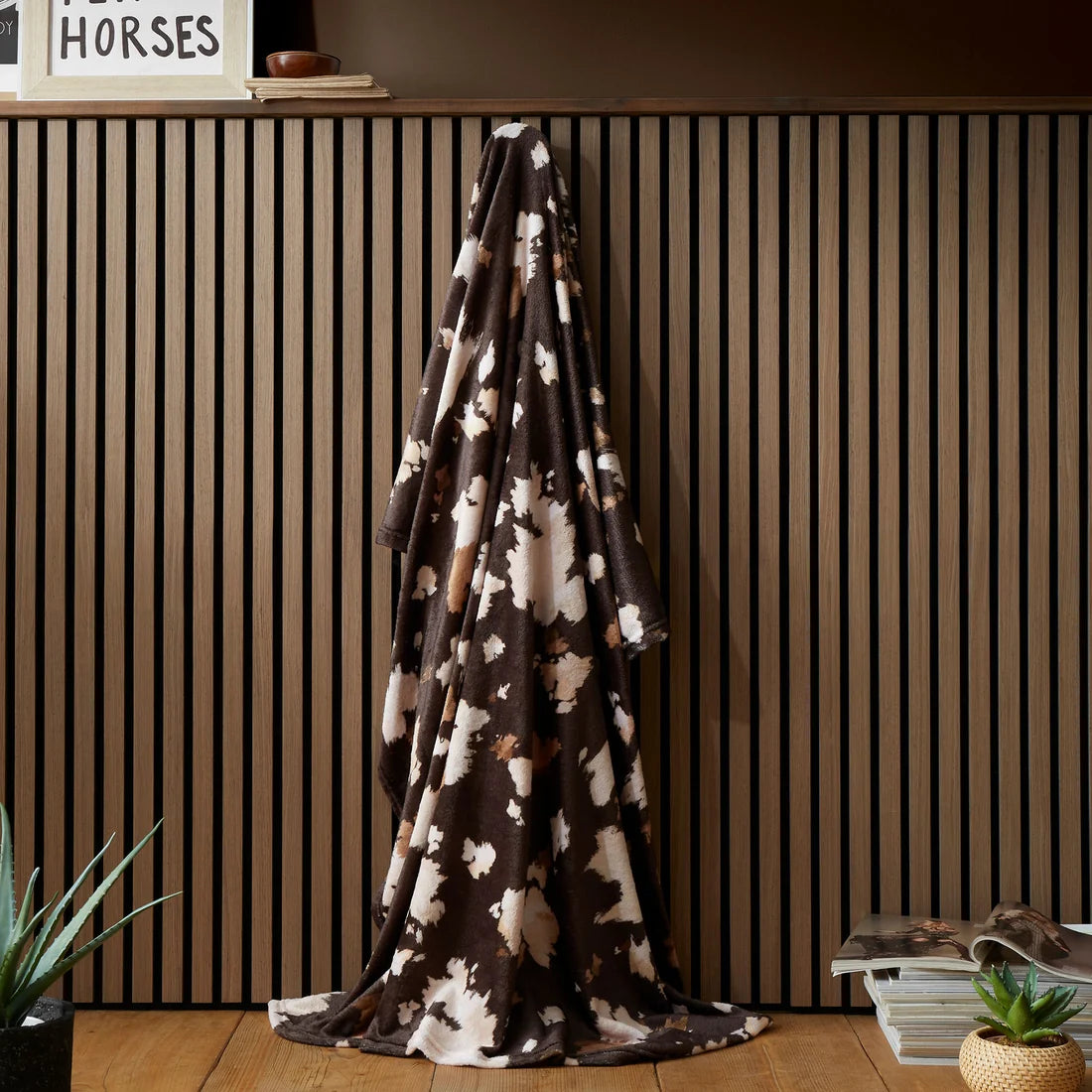 Fusion Cow Print fleece throw in chocolate with a cosy cowhide-inspired design.