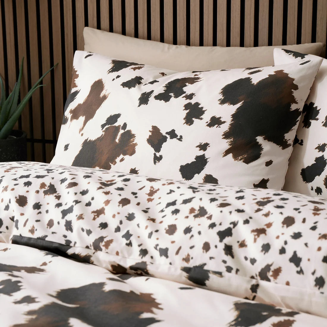 Close-up of the oversized painterly cowhide pattern on the Fusion Cow Print duvet cover set.