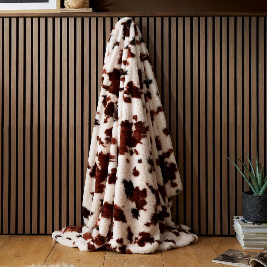 Fusion Cow Print Faux Fur bedspread in Natural 150 x 200cm with a bold cowhide-inspired design.