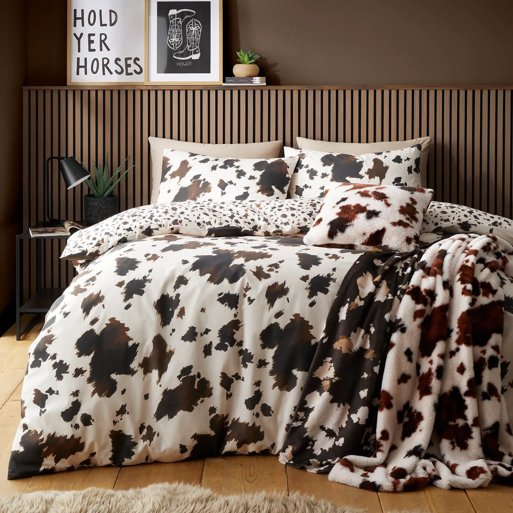 Fusion Cow Print Faux Fur cushion in Natural pictured with the matching duvet set and throw.