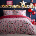 Christmas-themed bedding set with candy cane and bow pattern on a bed, decorated room with garland and ornaments.