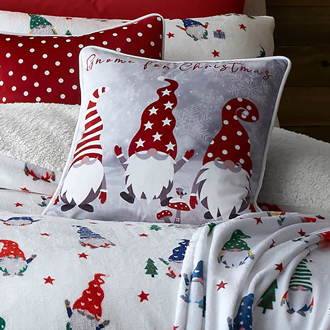 Close-up of the festive gonks, snowflakes and Gnome for Christmas slogan on the Fusion Christmas cushion.