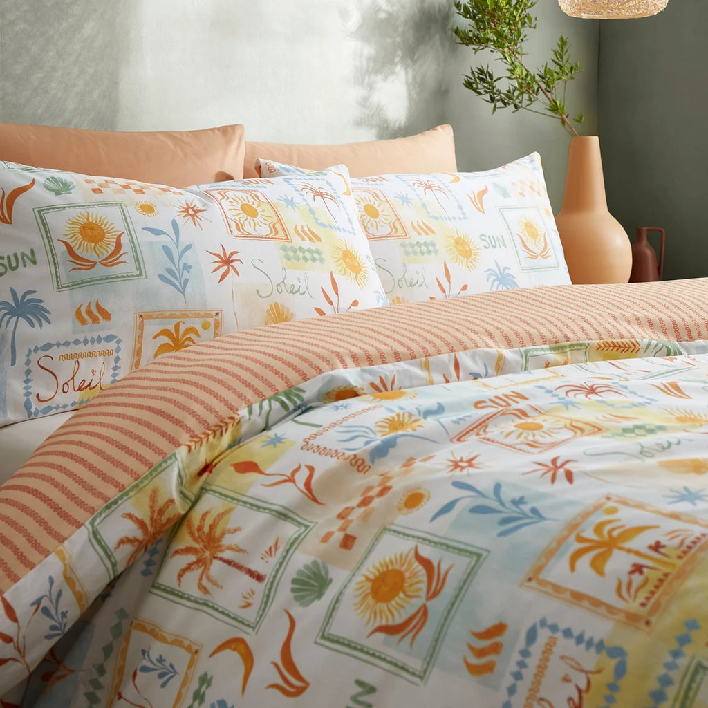 Close-up of the hand-drawn suns, palm trees and seashells on the Fusion Soleil duvet cover set.