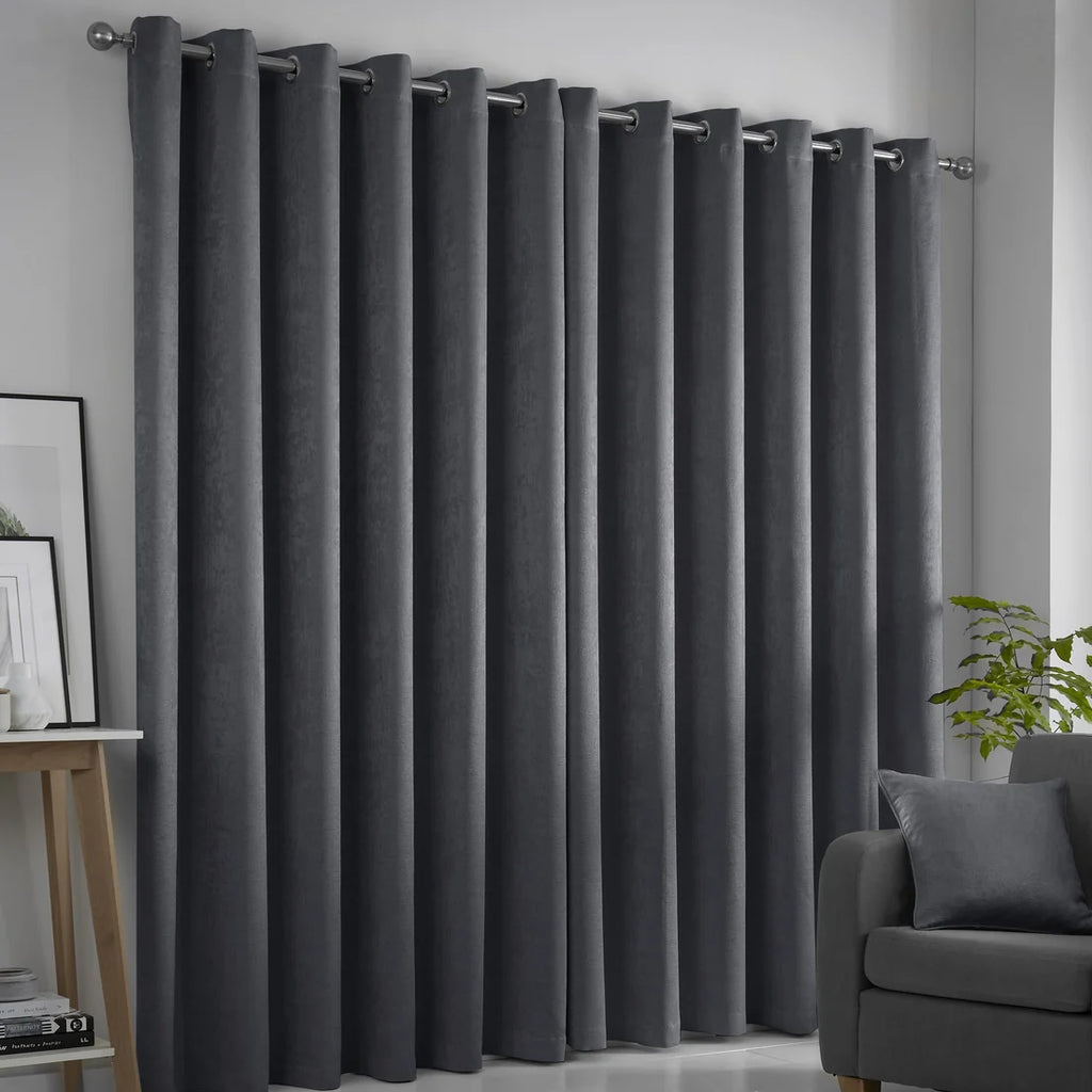 Fusion Strata charcoal eyelet curtains styled in a contemporary living room.