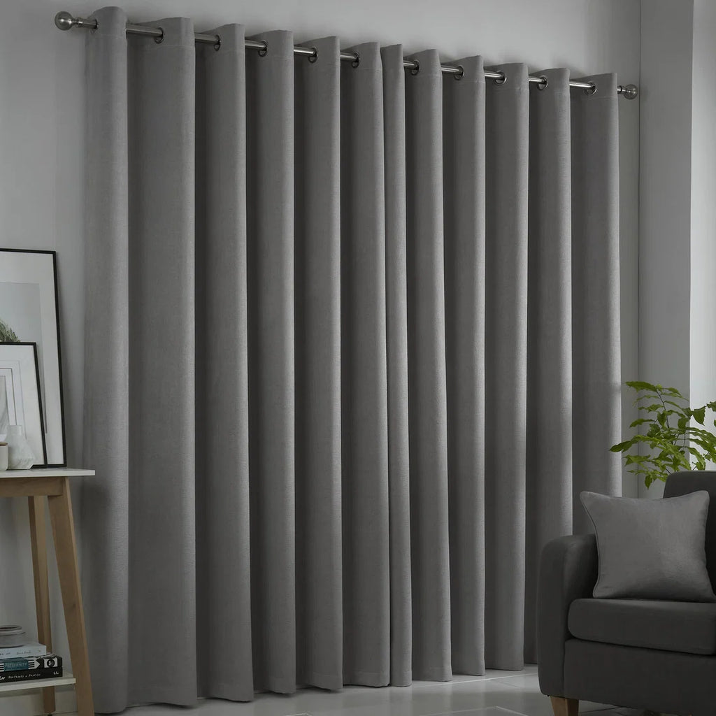 Fusion Strata silver eyelet curtains styled in a contemporary living room.