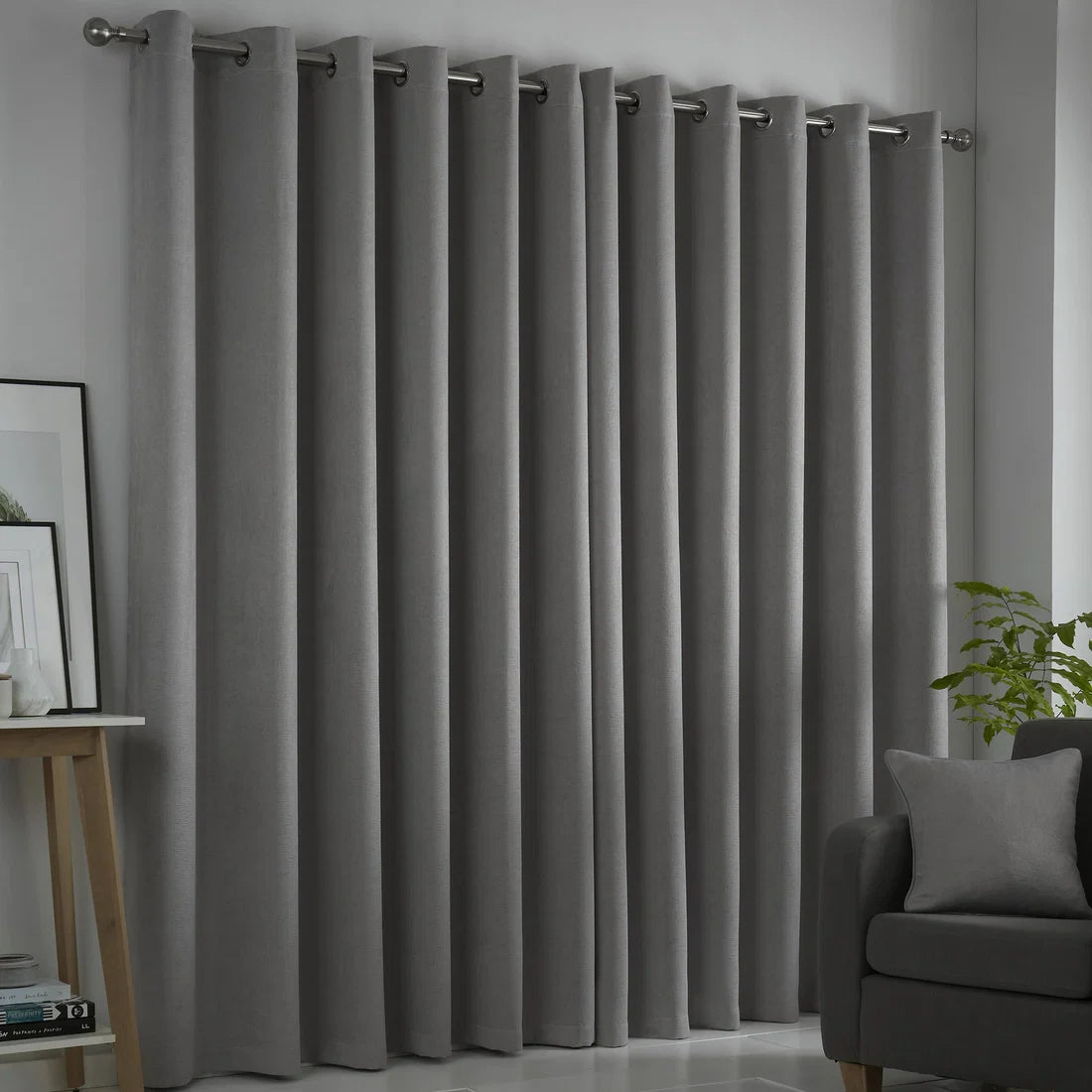 Fusion Strata silver eyelet curtains styled in a contemporary living room.