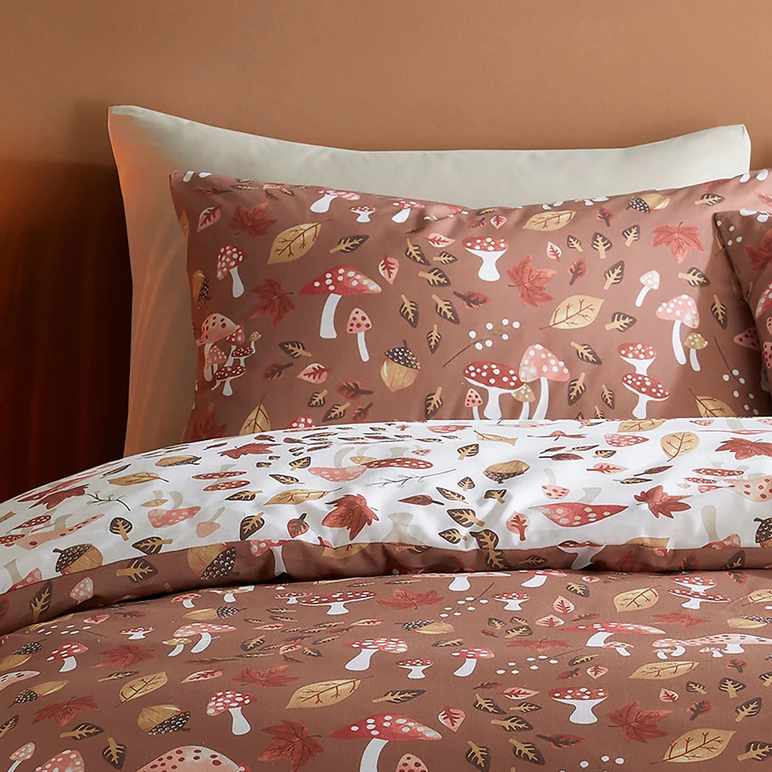 Close-up of the watercolour leaves and mushroom woodland design on the Fusion Woodland Dreams duvet cover set.