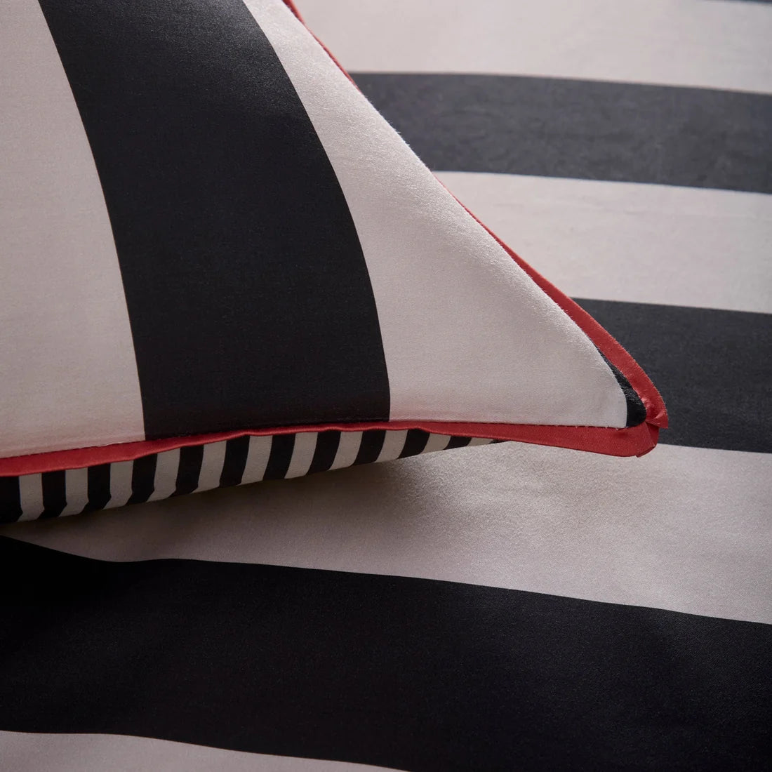 Close-up of the vibrant orange flat piping on the Laurence Llewelyn-Bowen Festivo Circus Stripe bedding.