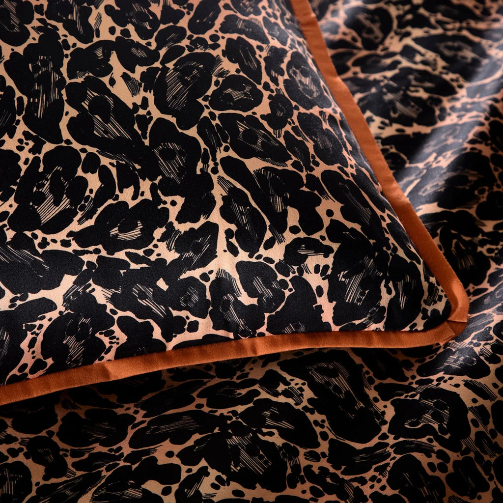 Close-up of the smooth 100% cotton sateen fabric and flat piped edging on the Roxy Leopard duvet cover set.