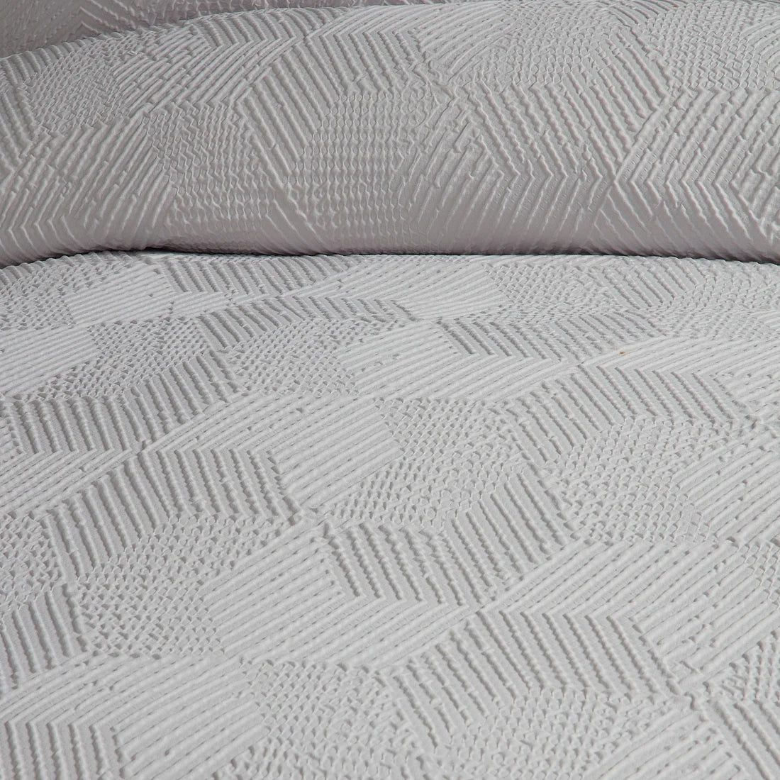 Close-up of the soft polyester fabric on the Serene Embossed Geo duvet cover set.