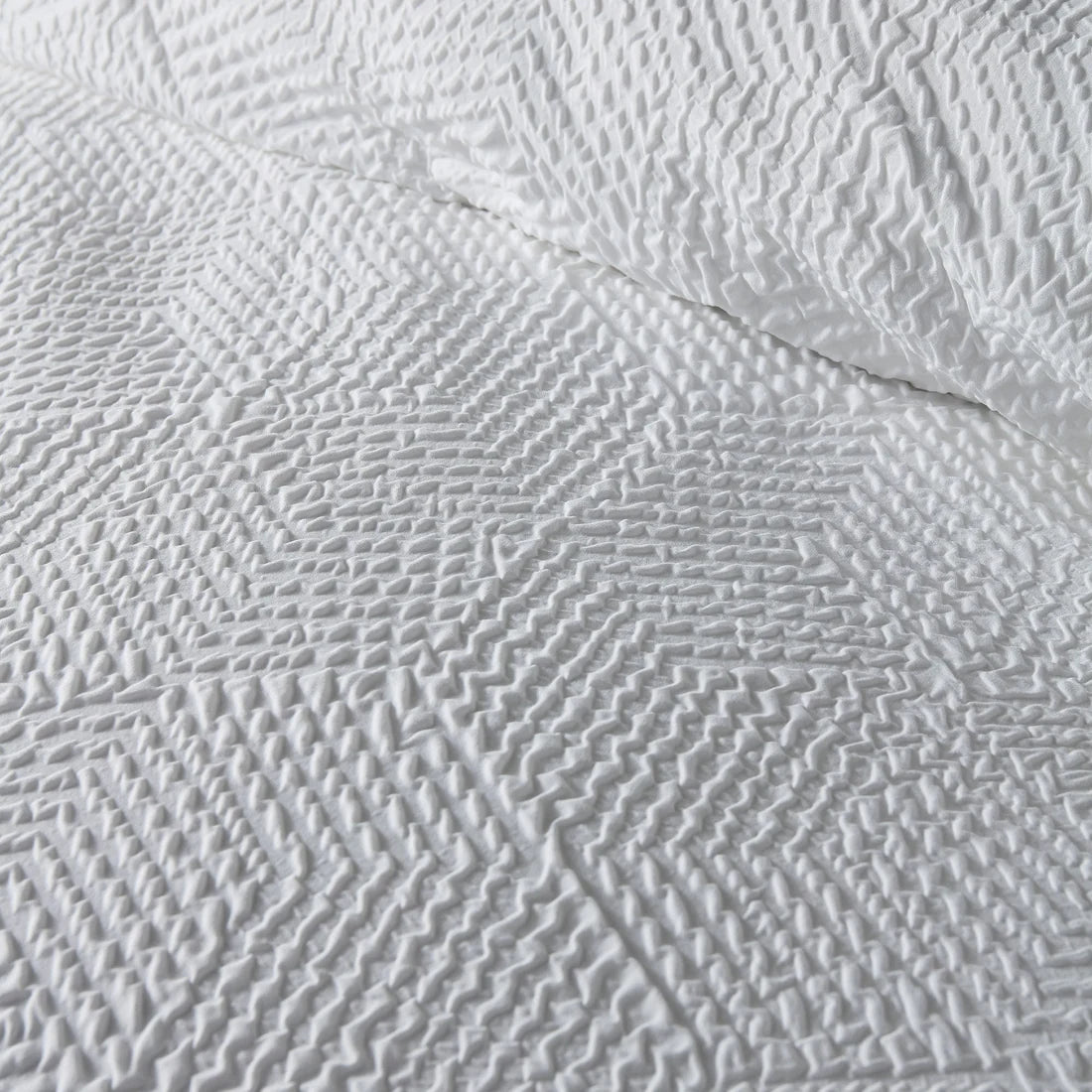Close-up of the soft polyester fabric on the Serene Embossed Geo duvet cover set.