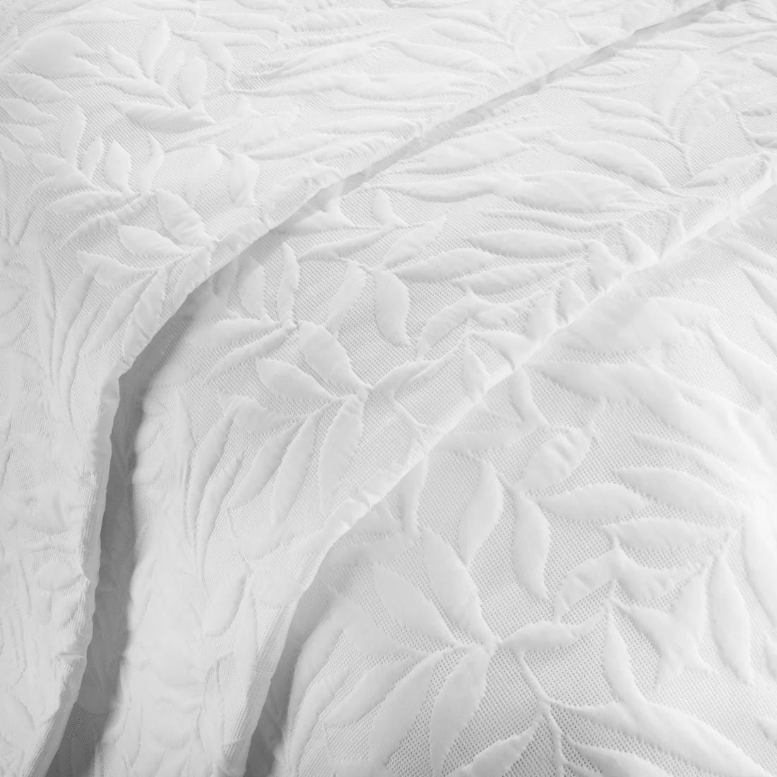Close-up of the raised floral Pinsonic pattern on the Serene Luana white bedspread.